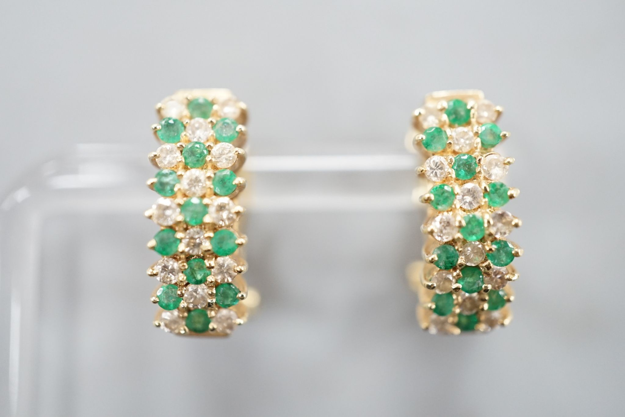 A pair of 14k yellow metal, emerald and diamond set curved earrings, 19mm, gross weight 7.4 grams.